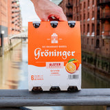 Gröninger Alster Orange Sixpack dass auf einer Rehling in der Speicherstadt steht