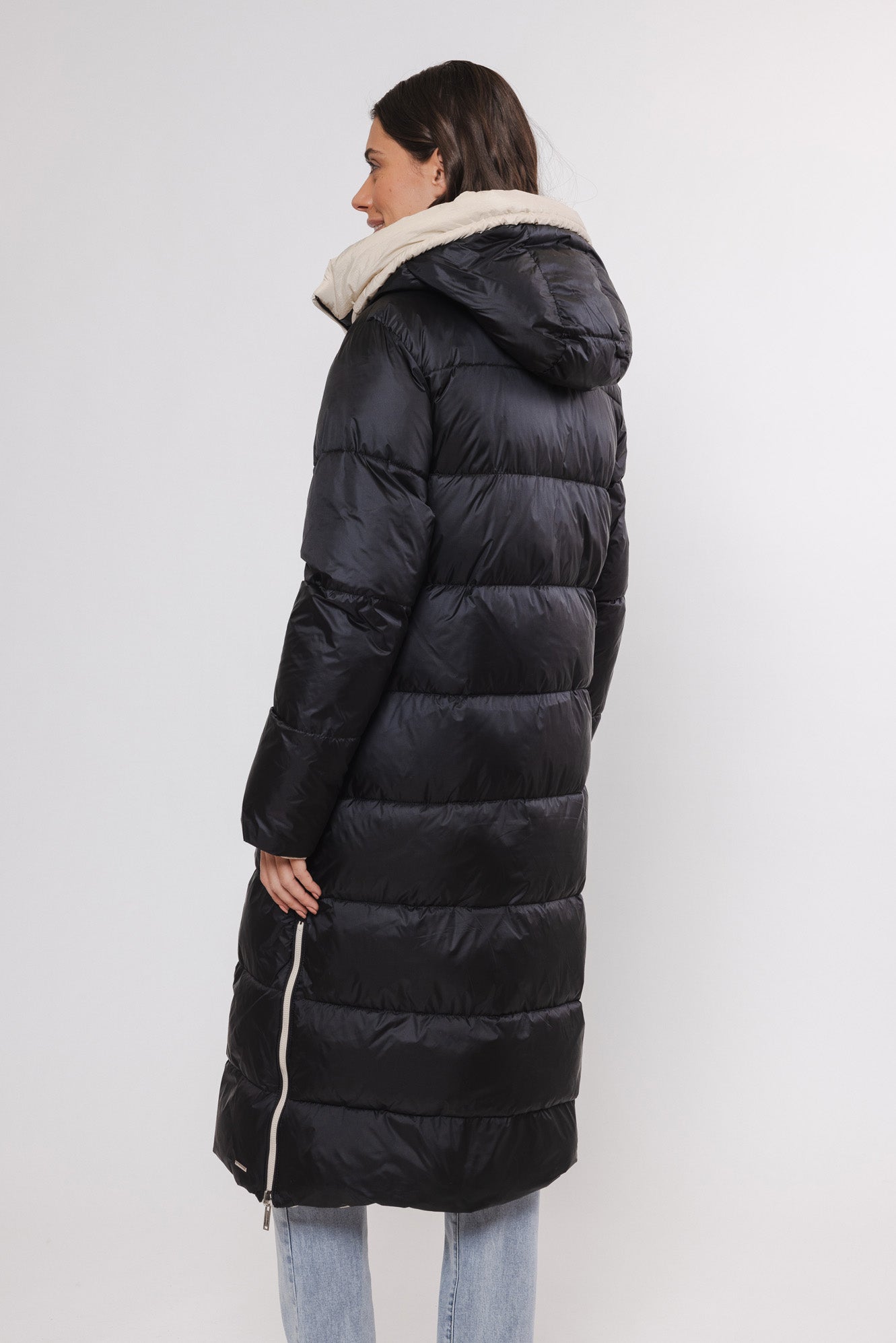 Model trägt einen Wintermantel wendbar in Schwarz und Beige von hinten