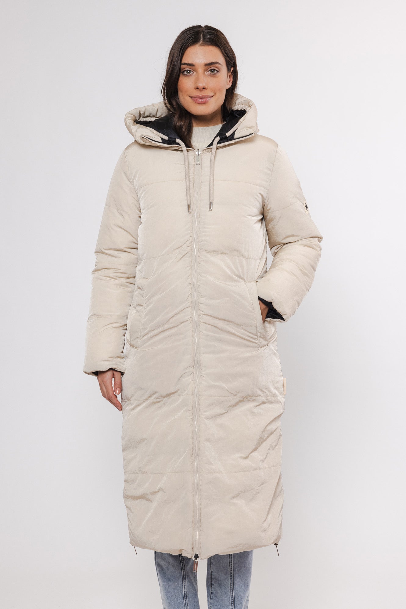 Model trägt einen Wintermantel wendbar in Schwarz und Beige Innenseite