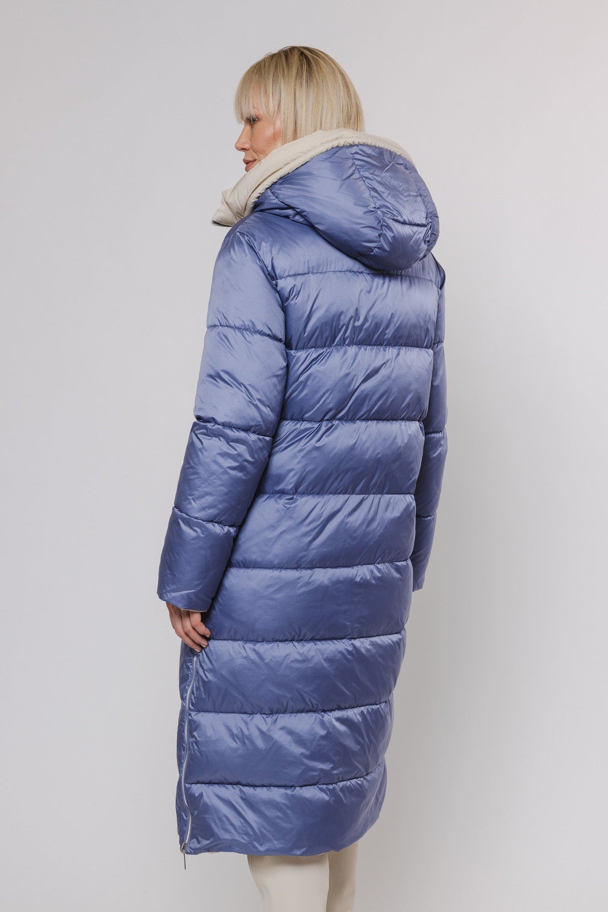 Model trägt einen Wintermantel wendbar in Blau und Beige von hinten